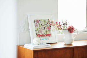 Botanical style pressed flower in white frame.